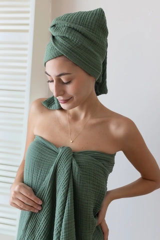 Folded sage green handwoven muslin towel in an airy interior, OEKO-TEX certified Turkish cotton