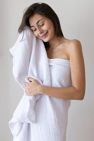 White 4-layer muslin bath towel styled in a bright bathroom — Turkish cotton, OEKO-TEX certified Denizli