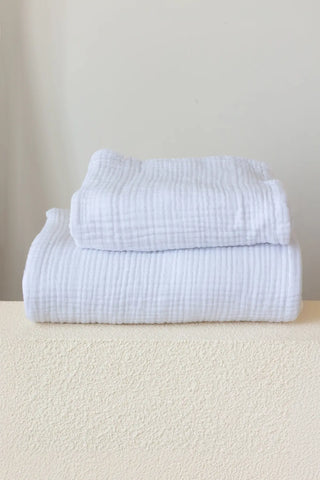 Folded white handwoven muslin towels detailing the airy 4-layer cotton texture by VivaMaison Denizli