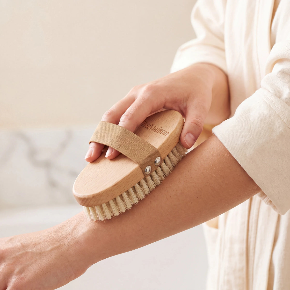 Natural bristle dry body brush held in the hand with the strap over the back of the hand - VivaMaison