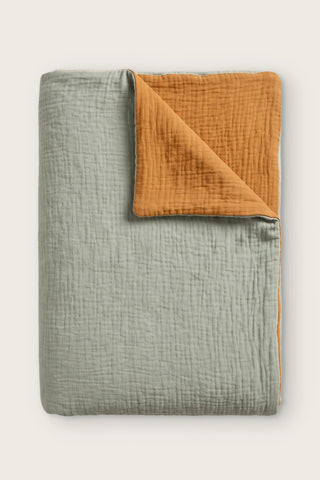 Reversible two-tone muslin duvet cover in sage green / caramel, folded view showing both sides