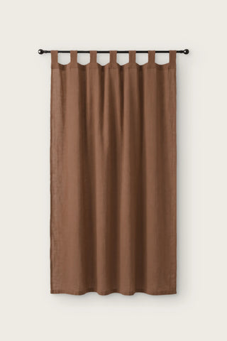 Stonewashed cotton curtain panel in brown, single tab top panel on a black rod, front view