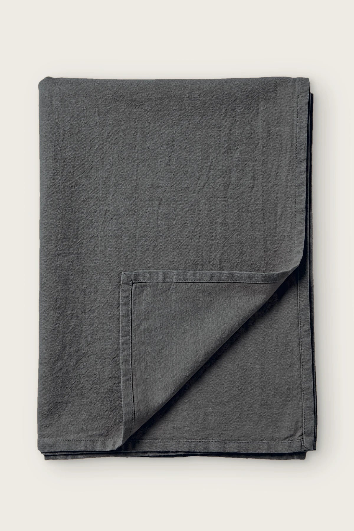 Anthracite handwoven stonewashed Turkish cotton tablecloth, folded with corner turned back. Vintage-soft Denizli, OEKO-TEX. VivaMaison