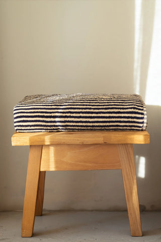 Navy striped Turkish cotton bath sheet folded on a wooden stool - VivaMaison