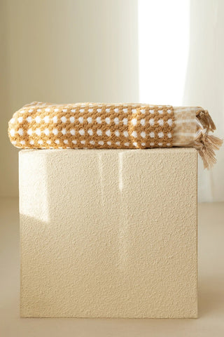 Mustard Turkish cotton mosaic towel folded on a plinth - VivaMaison