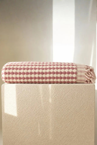 Pink Turkish cotton mosaic towel folded on a plinth - VivaMaison