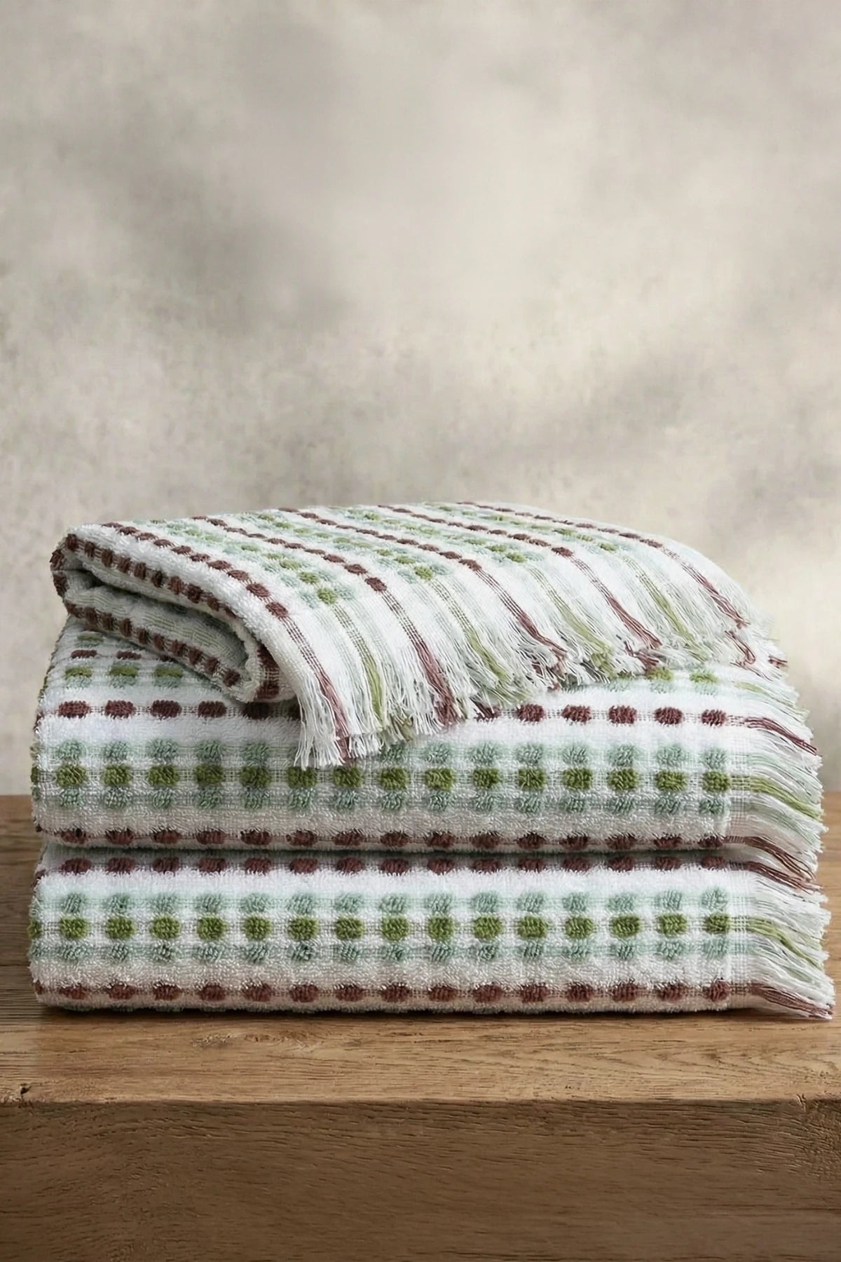 Sage Brown Turkish cotton mosaic towel stacked on a wooden bench - VivaMaison
