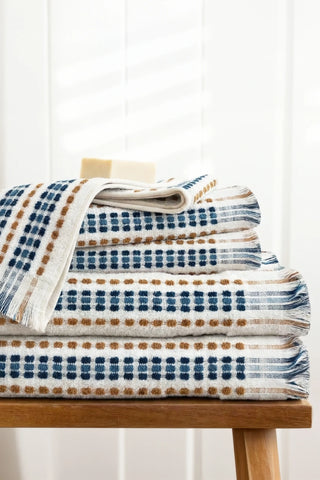Blue Brown Turkish cotton pom pom towel stacked on a wooden bench - VivaMaison