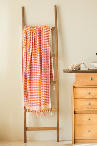 Orange Pink Turkish cotton pom pom towel hanging on a wooden ladder - VivaMaison