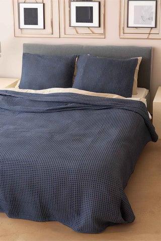 Anthracite waffle bedspread draped on bed showing honeycomb weave texture by Vivamaison