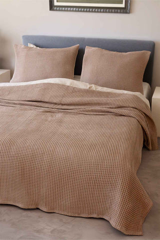 Natural waffle bedspread draped on bed showing honeycomb weave texture by Vivamaison