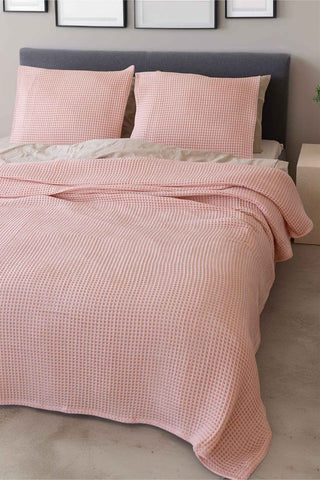 Natural waffle bedspread draped on bed showing honeycomb weave texture by Vivamaison